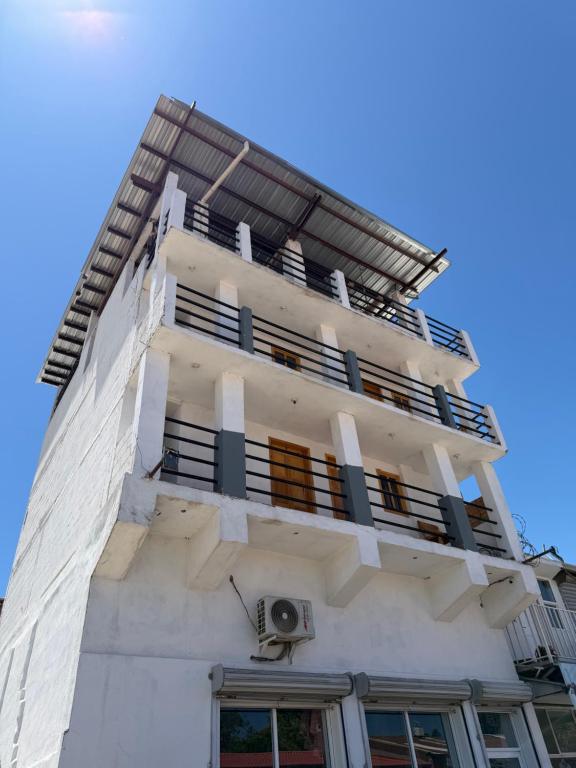 a tall white building with balconies on it at Hotel Mirador Creel in Creel
