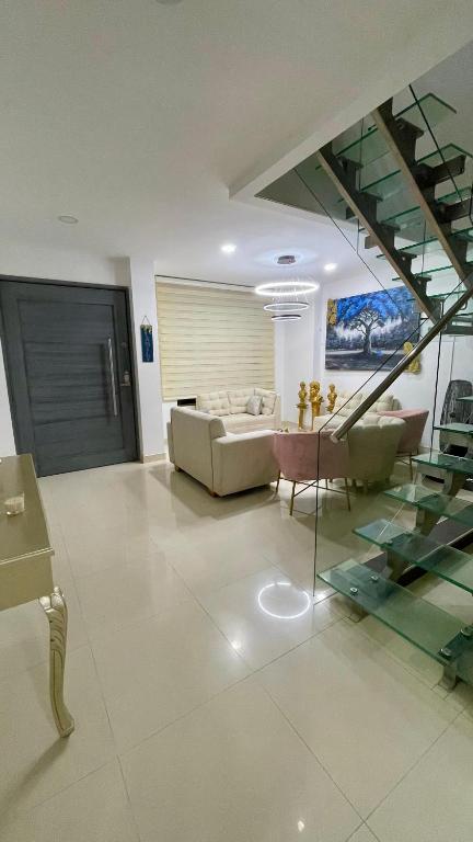 a living room with a couch and a glass staircase at Casa lujosa lorica in Lorica
