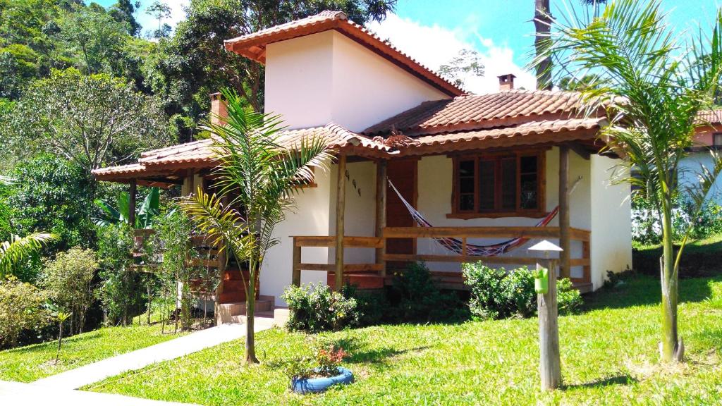 una pequeña casa en medio de un patio en Chalés do Pardal en Visconde De Maua