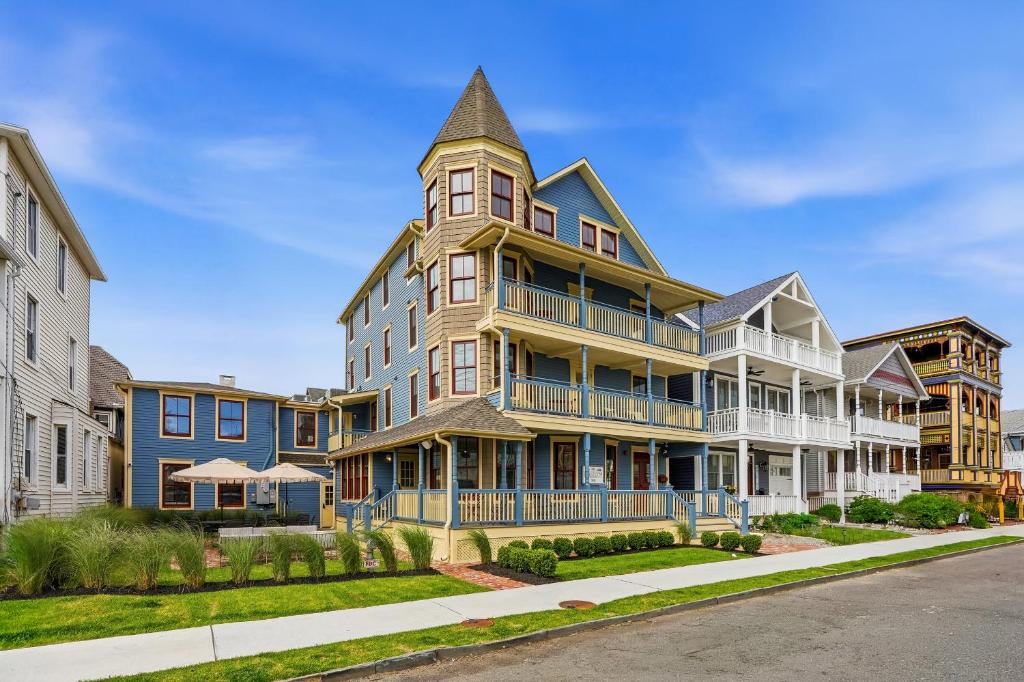 a large house with a turret on a street at The Marilyn Inn in Ocean Grove
