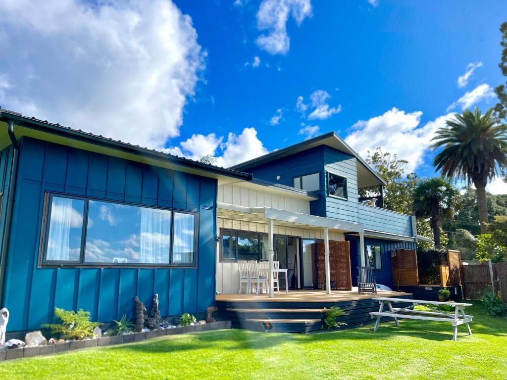 a blue and white house with a yard at Seaview Lodge in Tairua
