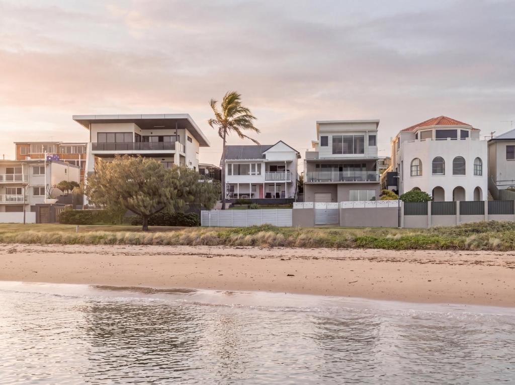 a row of houses on the beach near the water at The Pink Door, Absolute Beachfront House in Scarborough