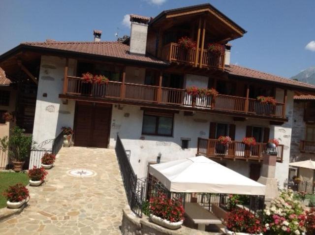 un gran edificio con balcones y flores delante de él en Casa Luigina, en Comano Terme