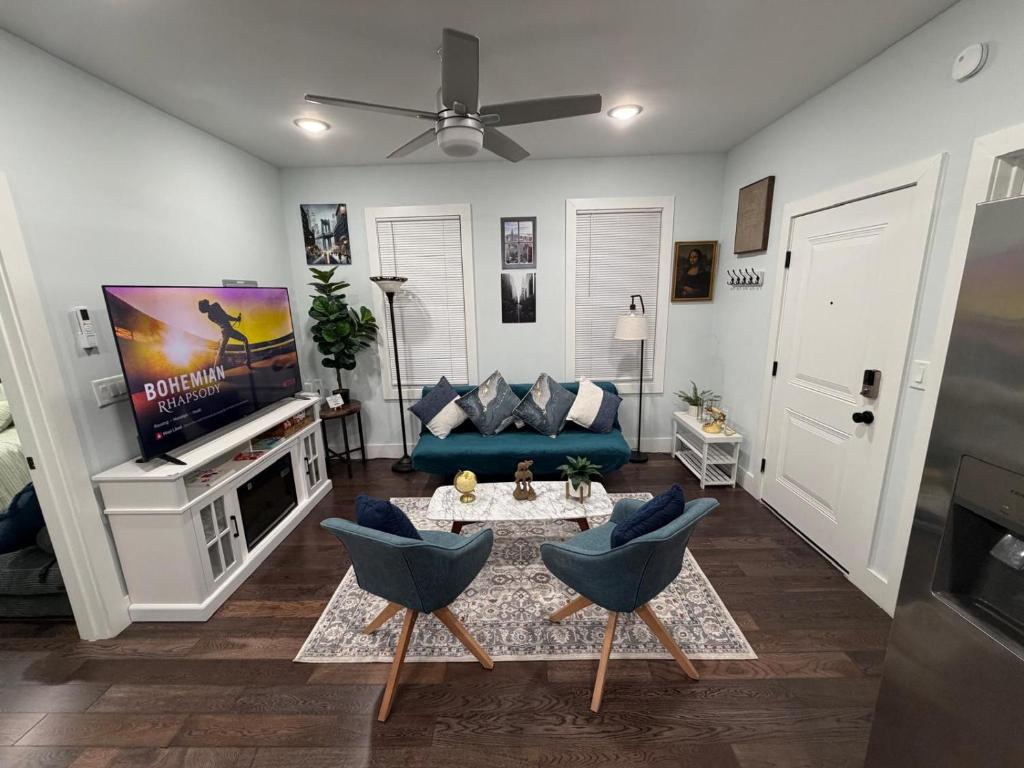 a living room with a blue couch and a tv at Modern & Spacious Apartment 15 Min to NYC Near MetLife & American Dream in Jersey City