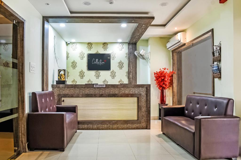 a waiting room with two chairs and a fireplace at Capital O Jai Adisson in Cuttack