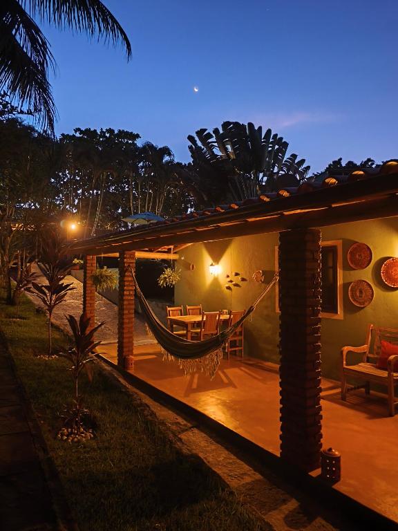 a house with a hammock on a patio at night at Pousada Casa Franco - Trancoso in Trancoso