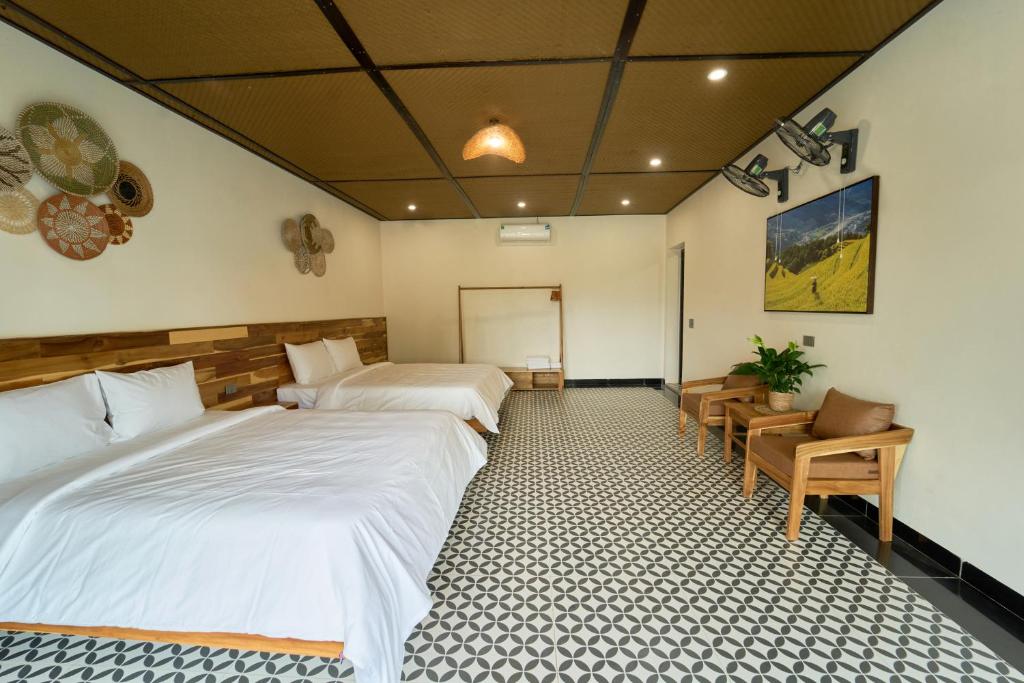 a hotel room with two beds and a table and chairs at Chài Homestay Sầm Sơn in Sầm Sơn