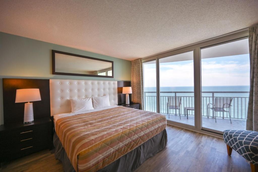 a hotel room with a bed and a balcony at Oceanfront Paradise Sleeps 10 w Stunning Sunrises in Myrtle Beach
