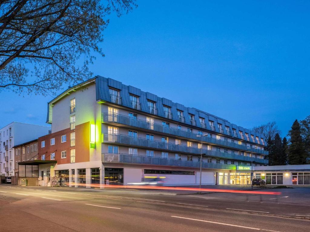 a building on the side of a street at night at ibis Styles Graz Messe in Graz