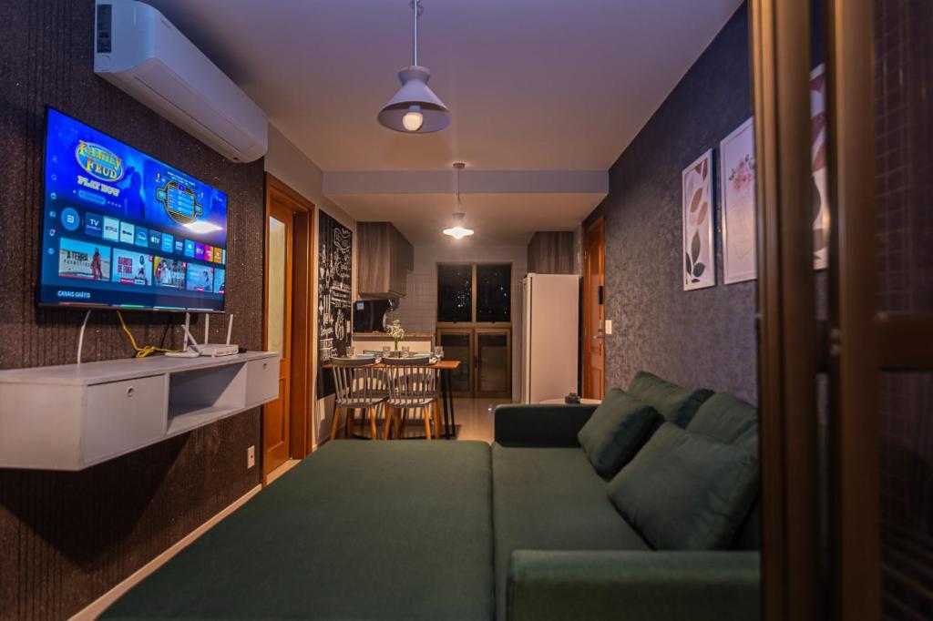 a living room with a green couch and a television at Refúgio do poeta in Natal
