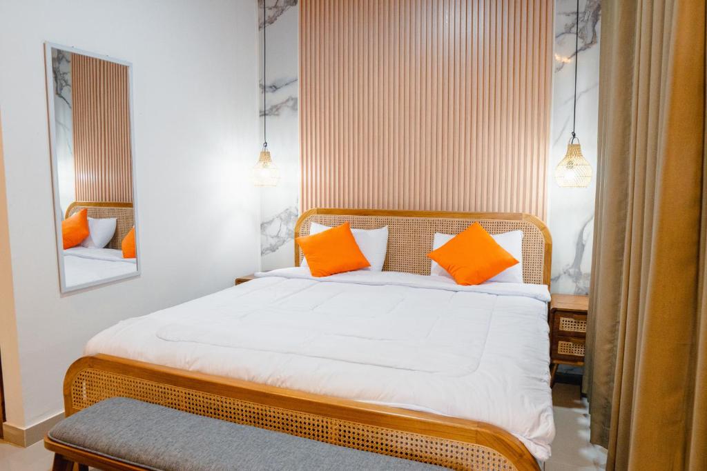 a bedroom with a bed with orange pillows at Ricefield View 2 BR villa near Canggu in Dalung