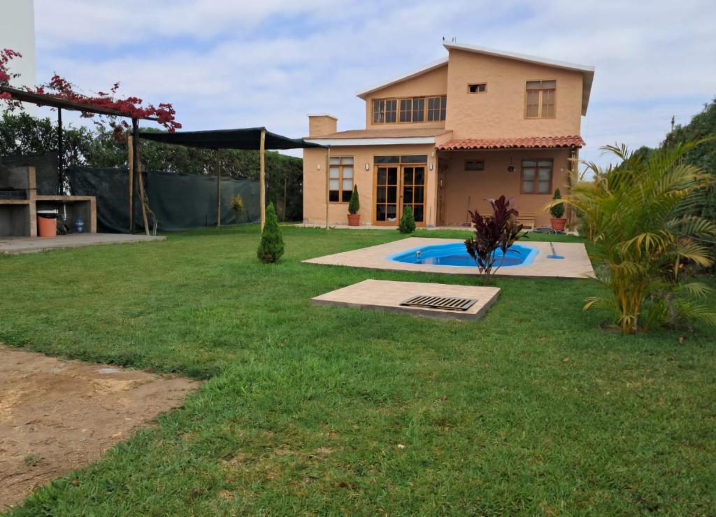 a house with a yard with a swimming pool at Villa Luna in Chincha