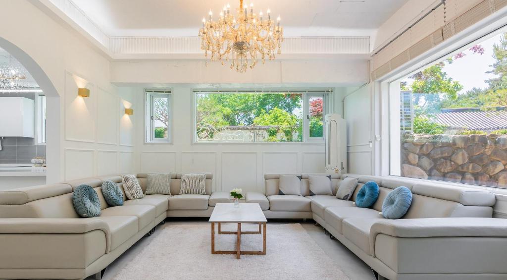a living room with couches and a chandelier at 초음정 Luxury Hanok Style Villa with Private Garden in Gyeongju in Gyeongju
