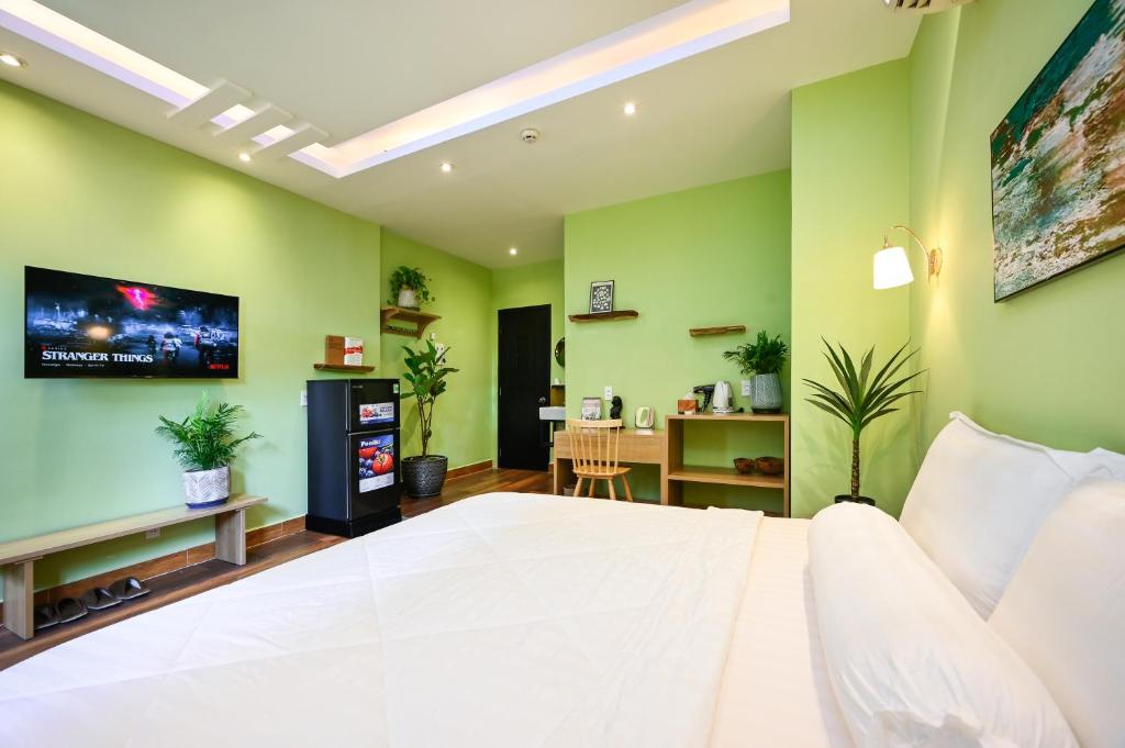 a bedroom with a white bed and a tv on the wall at Harmony Stay - Ben Thanh Market in Ho Chi Minh City