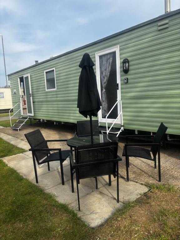 a table and chairs in front of a green trailer at Green Goddess in Skipsea