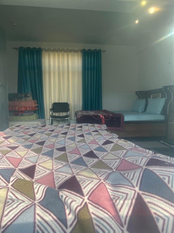 a bedroom with a large bed with a colorful comforter at Bittu Homestay in Kaza
