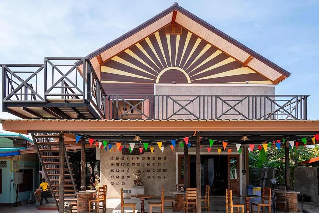 a building with a lot of tables and flags on it at Smilingface guesthouse in Sukhothai