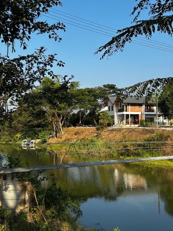 a house on a hill next to a body of water at Glai boutique hotel in Ban Cha Prong