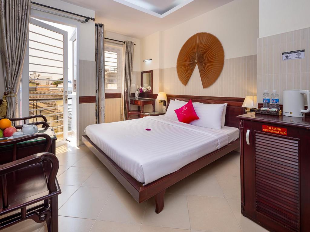 a bedroom with a large bed and a balcony at Pink Horizon Saigon Airport Hotel in Ho Chi Minh City