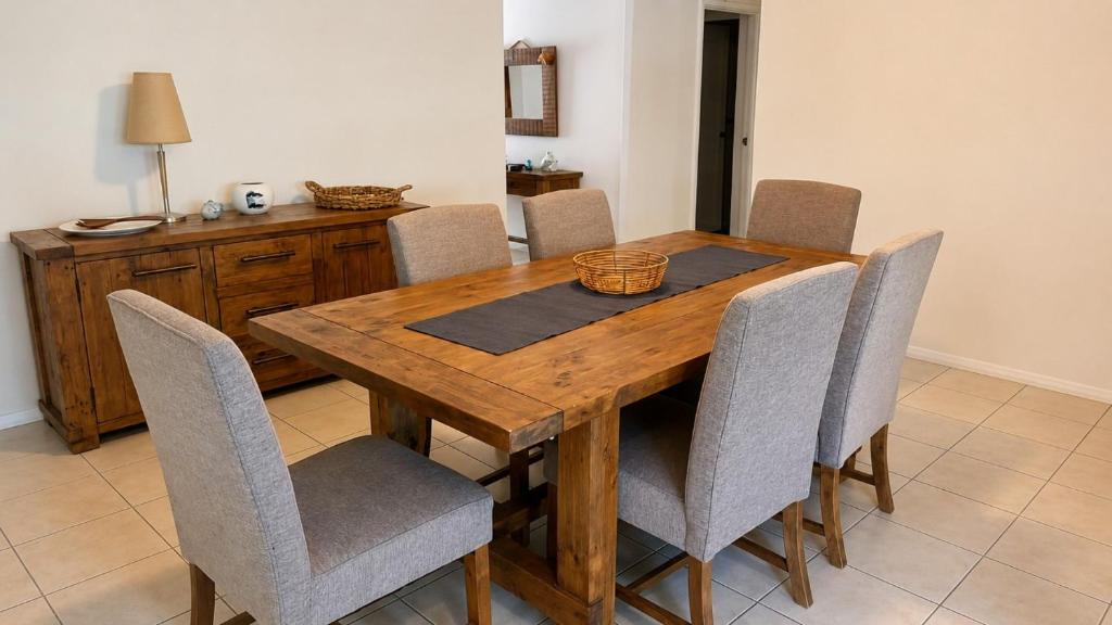 a wooden dining room table with chairs and a basket on it at Beachside on Kent in Busselton