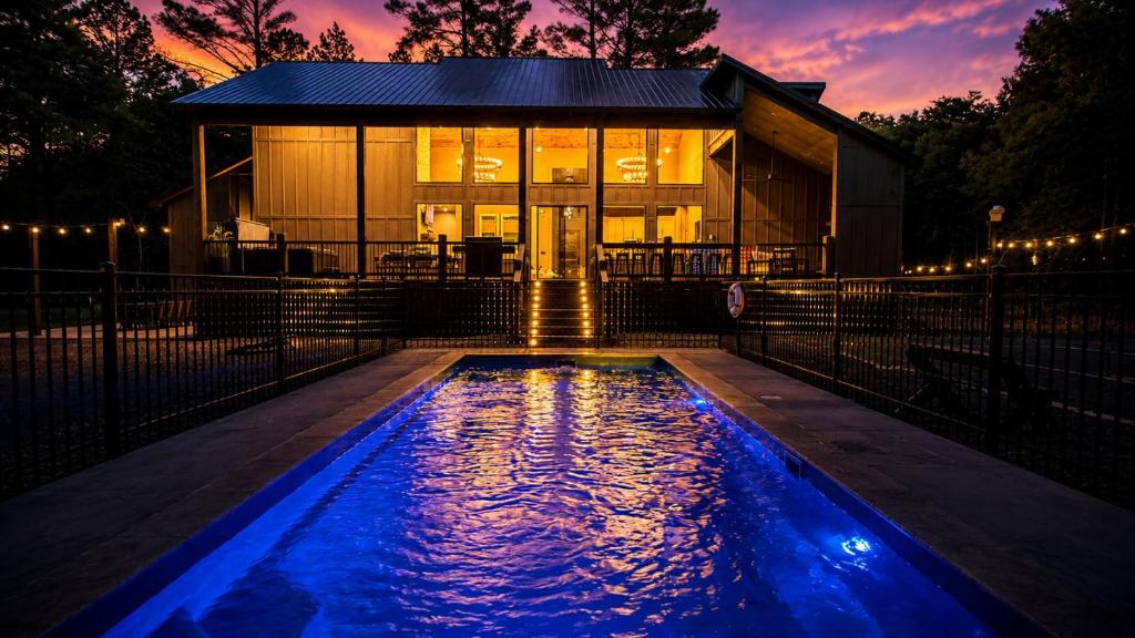 a house with a swimming pool in front of a building at Creek,Pool,Playhouse celebration estate, sleeps 21 in Broken Bow
