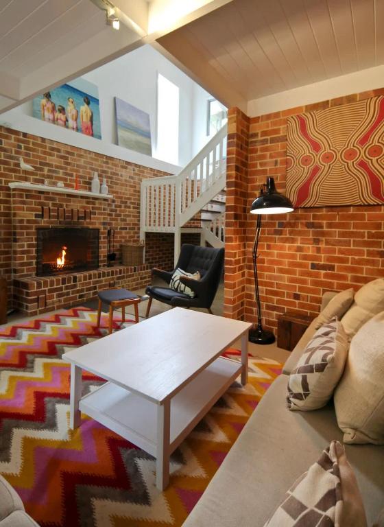 a living room with a brick wall and a fireplace at Edgewater on Quindalup Beachfront in Quindalup
