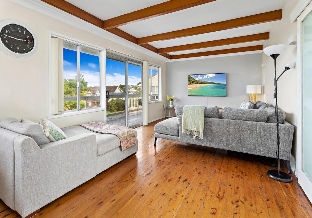 a living room with two couches and large windows at Tabone on Jones in Kiama Downs