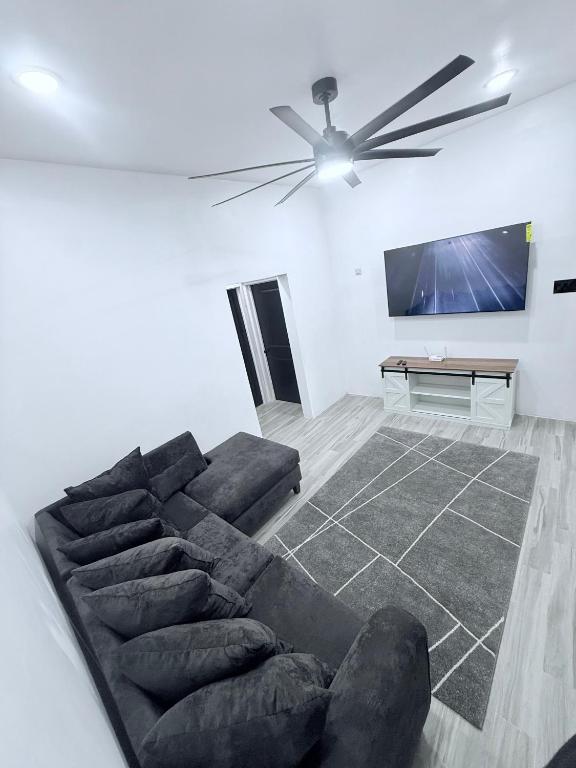 a living room with a couch and a flat screen tv at Modern Caribbean retreat 2 in Kingston