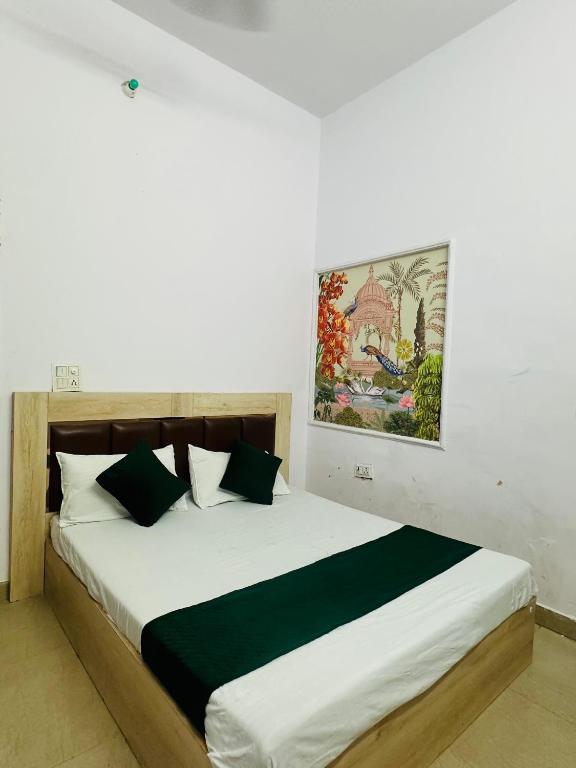 a bedroom with a large bed with a painting on the wall at Hotel park view in Bathinda
