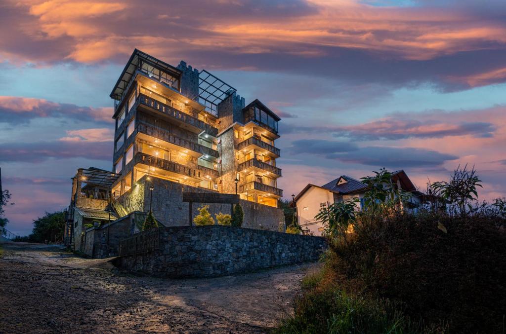 a tall building with lights on it at dusk at Fort WindShire in Nuwara Eliya