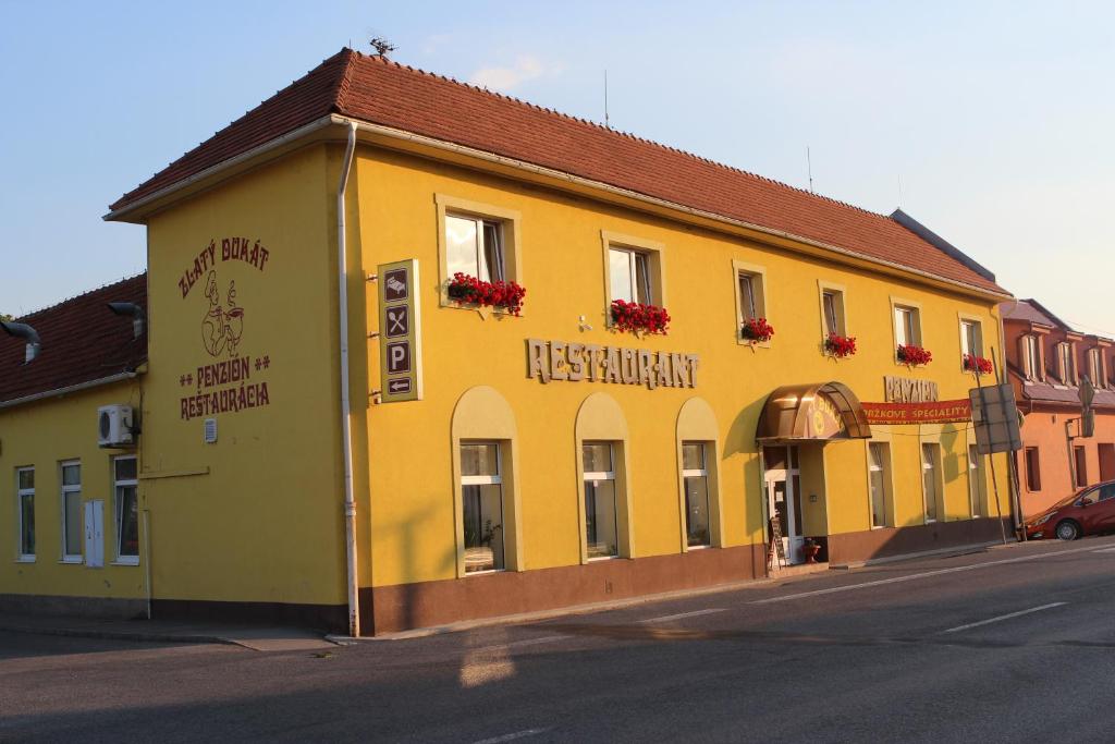 um edifício amarelo no lado de uma rua em Penzión Zlatý Dukát em Zvolenská Slatina