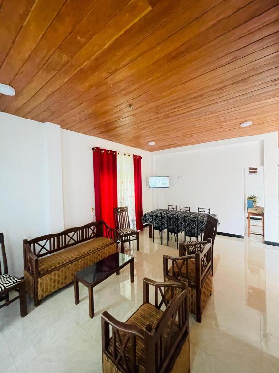 a room with tables and chairs and a wooden ceiling at Veenu Homestay in Badulla