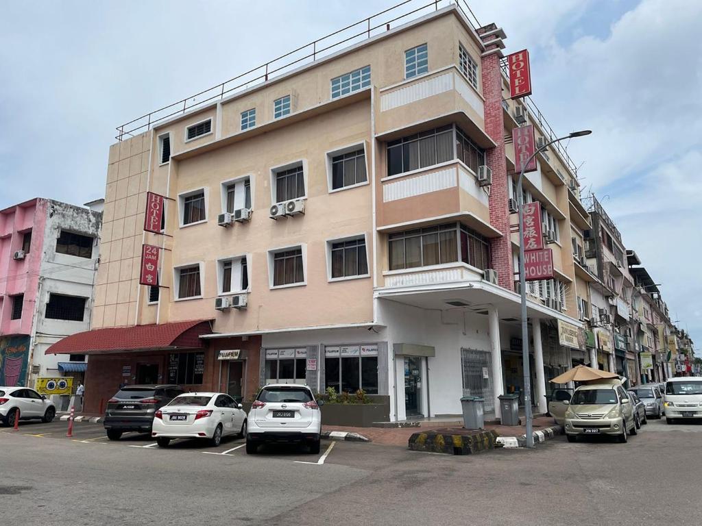 a large building with cars parked in a parking lot at White House Hotel Kluang in Kluang