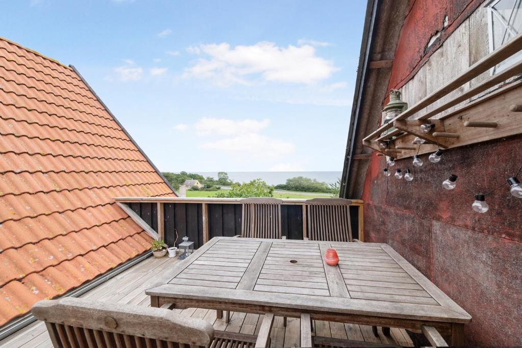 a wooden table on the balcony of a building at Holiday Apartment On Bornholm With Sea View in Svaneke