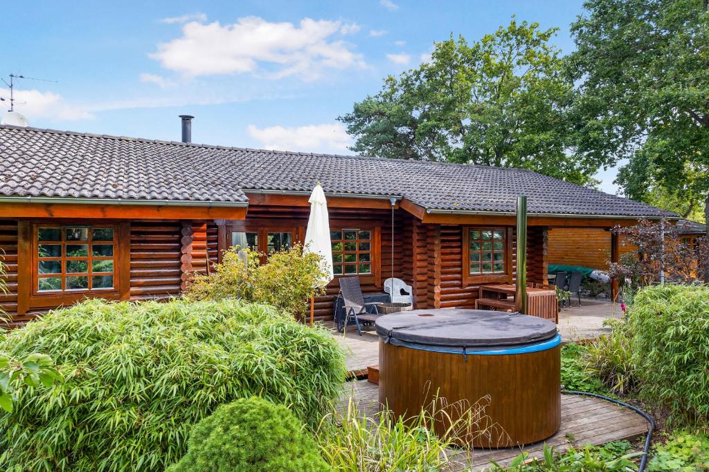 a log cabin with a hot tub in the yard at Charming Cabin With Wilderness Hot Tub in Asnæs