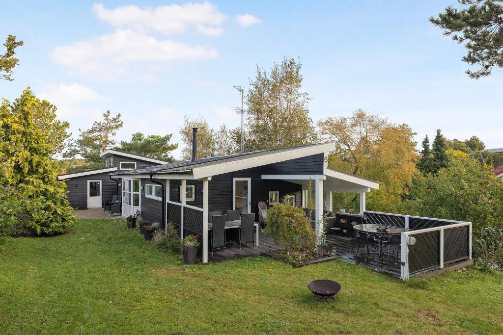a black house with a grill in the yard at Close To The Beach And Forest And Ebeltoft in Ebeltoft