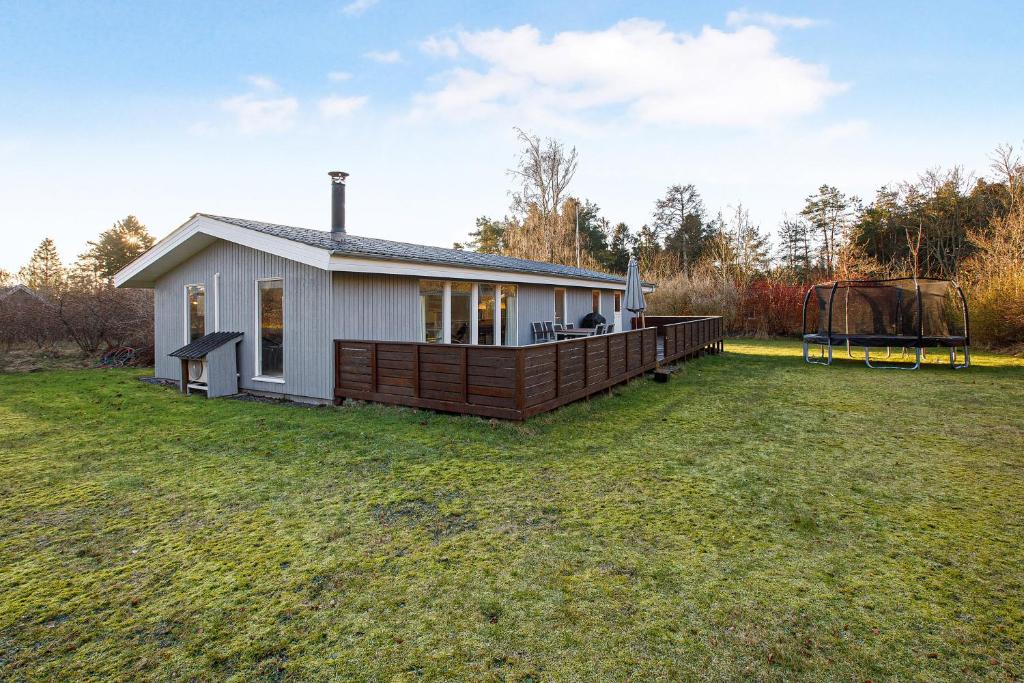 a small white house with a large yard at Cozy Summer House On Scenic Djursland in Glesborg