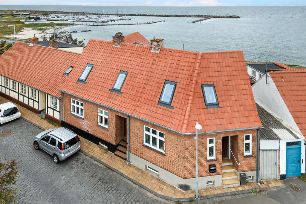 an orange roofed house with a car parked in a parking lot at Spacious House With Sea Views From All Rooms in Rønne