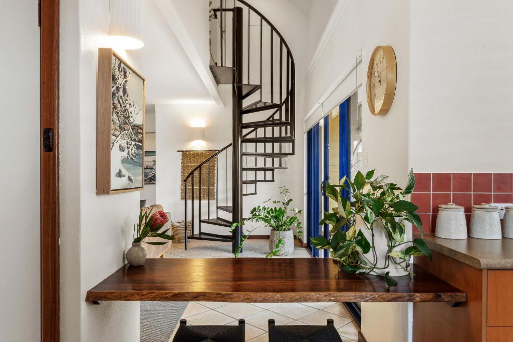 a kitchen with a wooden table and a spiral staircase at Sidney Laine - Family Friendly - Private in Margaret River Town