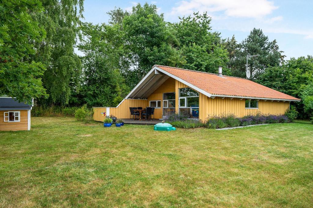 a small yellow house in a yard at Family-Friendly Cottage Near The Beach in Gilleleje