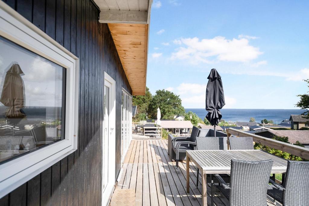 a patio with tables and chairs and a view of the ocean at Beautifully Situated Summer House With Sea View in Allinge