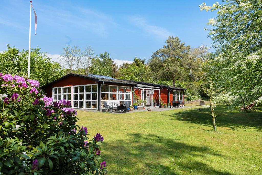 a large red building with windows and a yard at Lovely Cottage In Recreation Area in Åkirkeby