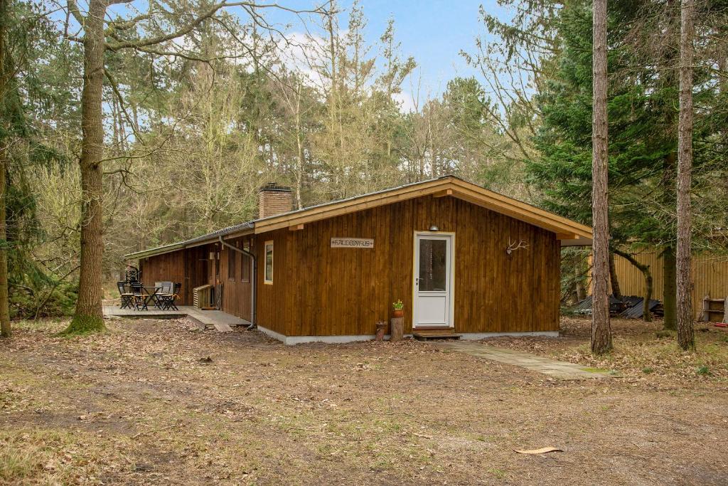 a wooden cabin in the middle of a forest at Nice Summer House In The Middle Of The Forest in Store Fuglede