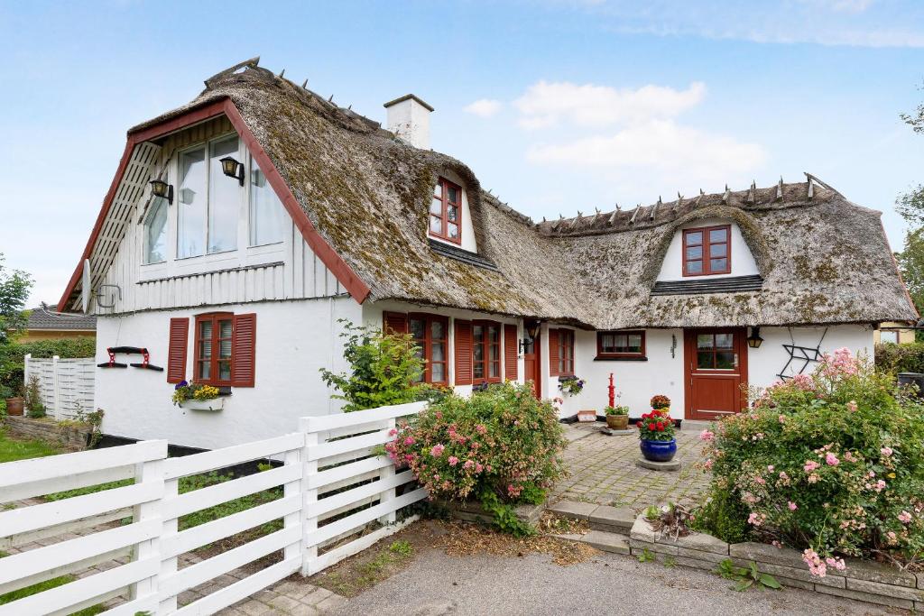 a white house with a thatched roof at New Renovated Farmhouse in Slagelse