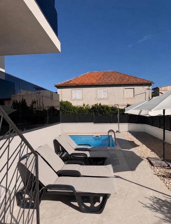 a swimming pool on a patio with a house at Palm Blues in Vodice