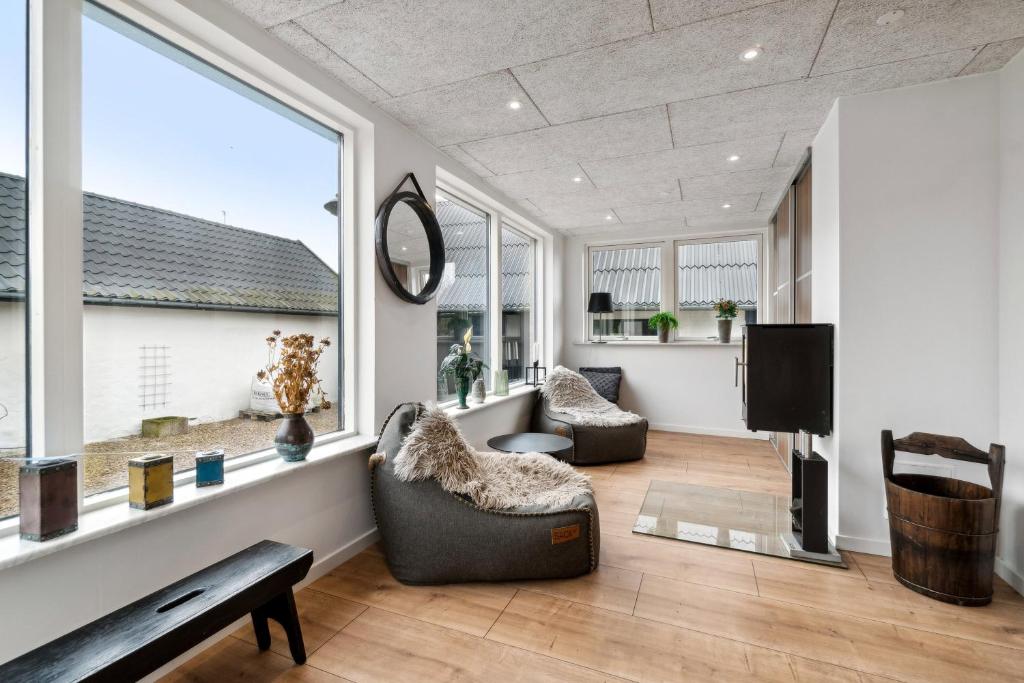 a living room with two chairs and a tv at Modern House With Space For Relaxation in Åkirkeby