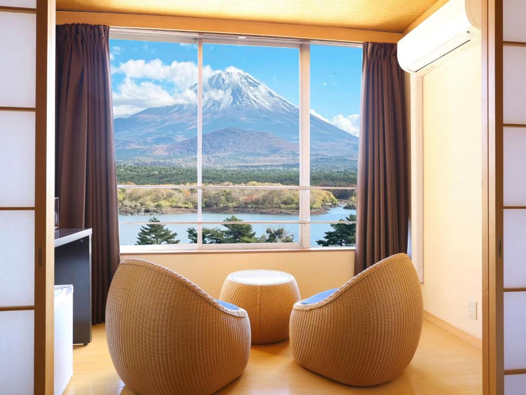 a room with a view of a mountain through a window at Shoji Mount Hotel in Fujikawaguchiko