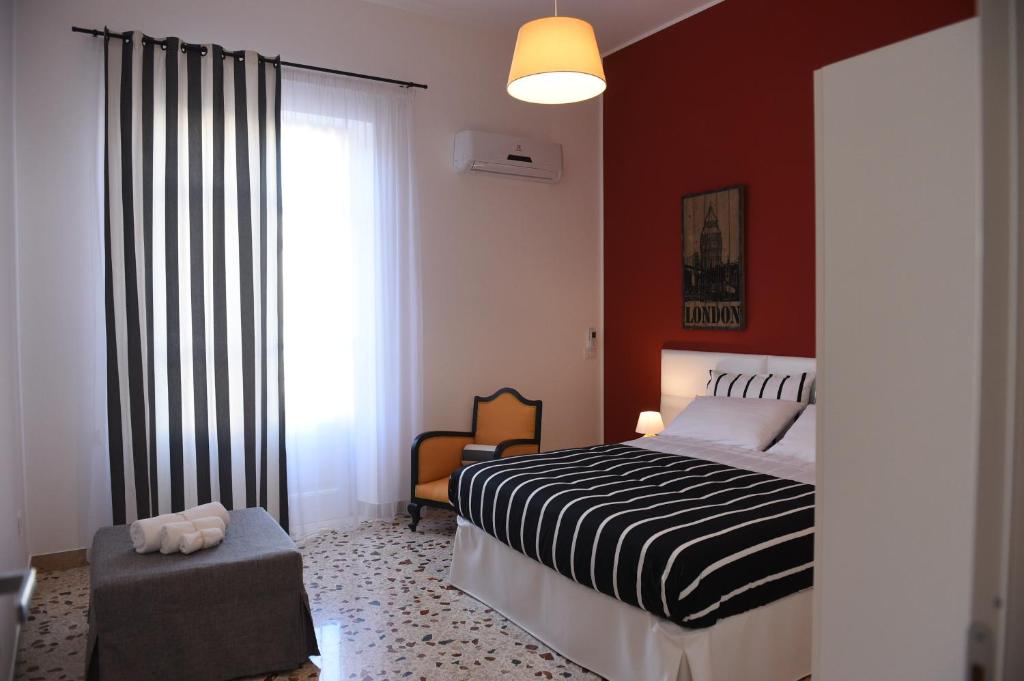 a bedroom with a black and white bed and a window at Chic Apartment Le Monde in Castellammare del Golfo