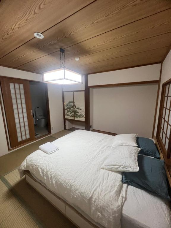 a bedroom with a large bed with a wooden ceiling at Momo Lodge Madarao in Iiyama