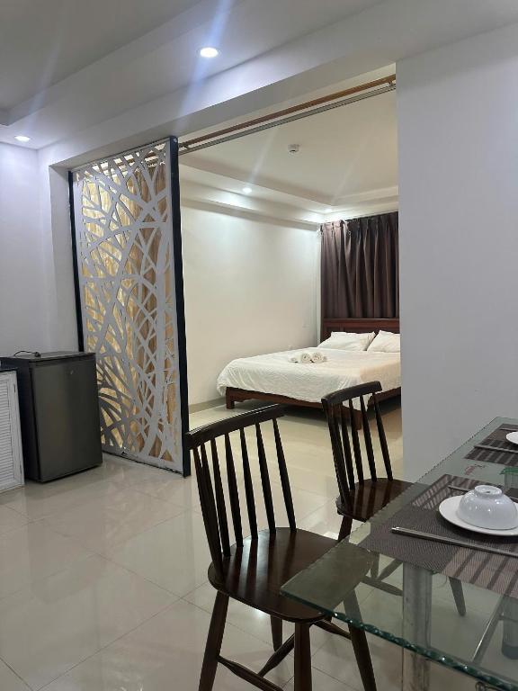 a room with a table and chairs and a bed at Full House Hotel Apartment in Danang
